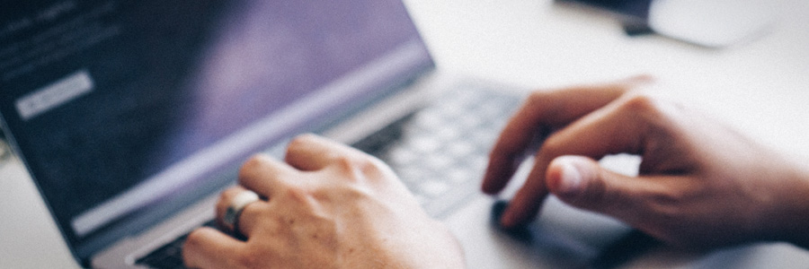 Hands typing on laptop keyboard